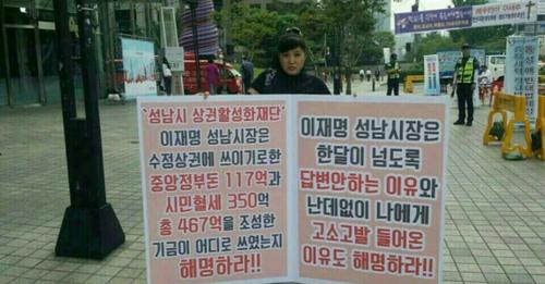  이재명 경기지사가 성남시장이던 시절 김사랑씨가 이 지사에게 항의하는 피켓 시위를 하고 있다. (사진=김사랑씨 페이스북 캡처)