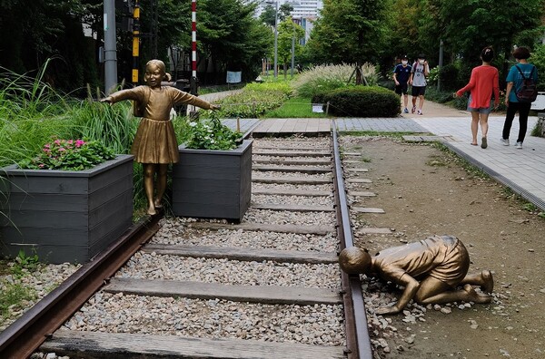 레일에 귀를 대고 기차오는 소리를 듣는 어린 아이 조각. (사진=황현탁)