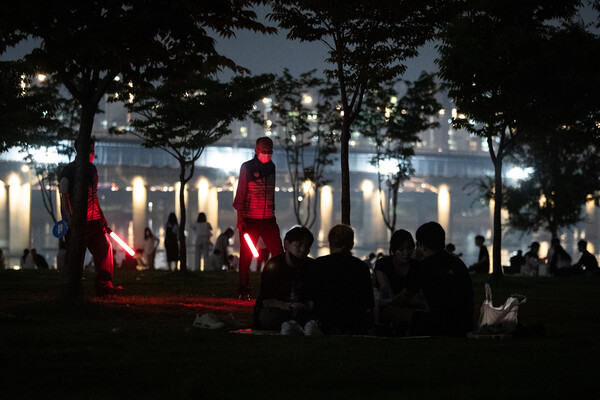 지난 7월 6일 밤 여의도 한강공원에서 서울시 한강사업본부 직원들이 시민들에게 10시 이후 야간 음주금지 안내 및 계도 활동을 하고 있다. (사진=뉴스1)