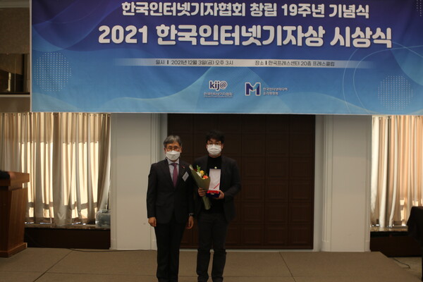 뉴스버스 전혁수 기자(오른쪽)가 3일 오후 프레스센터에서 열린 '2021년 한국인터넷기자상 시상식'에서 보도부문 본상을 수상한뒤 시상자와 기넘촬영하고 있다. (사진=뉴스버스) 