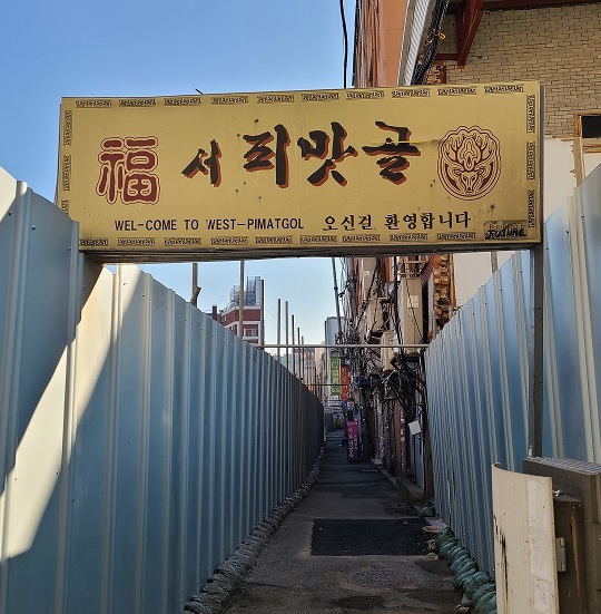 재개발 공사 가림막 사이 골목 위로 '서 피맛골' 간판이 걸려 있다. (사진=황현탁)