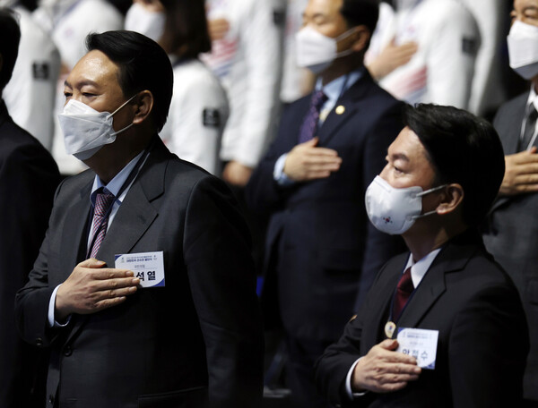 윤석열 국민의힘 대선후보(왼쪽)와 안철수 국민의당 대선후보가 지난달 25일 오후 서울 송파구 올림픽홀에서 열린 2022 제24회 베이징 동계올림픽 선수단 결단식에 참석해 국민의례를 하고 있다. (사진=뉴스1)