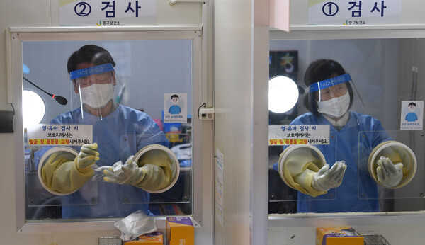 안철수 국민의당 대선 후보의 배우자 김미경 교수(오른쪽)가 설 연휴 마지막 날인 지난 2일 서울 중구보건소 선별진료소에서 안 후보와 함께 코로나19 검체 채취 의료봉사 활동을 하고 있다. (사진=뉴스1)