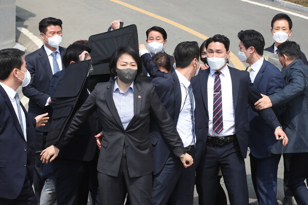 박근혜 전 대통령이 24일 오후 대구 달성군 사저 앞에서 대국민 메시지를 발표하는 도중 소주병이 날아들자 경호원들이 박 전 대통령을 감싸고 있다. (사진=뉴스1)