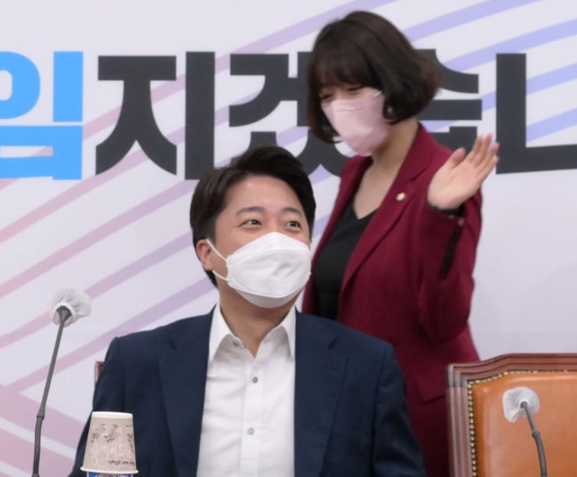 악수를 패싱 당한 뒤 다시 돌아서 온 배 최고위원이 자리에 착석해 앉아 있는 이 대표의 어깨를 손바닥으로 치고 있다. (사진=뉴스1)