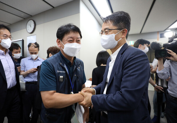 박준식 최저임금위원회 위원장(오른쪽)이 29일 밤 정부세종청사 최저임금위원회 회의실에서 열린 제8차 전원회의에서 최저임금 9,620원이 확정된 뒤 한국노총 근로자위원들과 악수를 하고 있다. (사진=뉴스1)