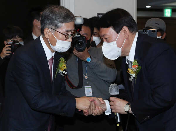 윤석열 국민의힘 대선후보가 9일 서울 중구 한국프레스센터에서 열린 신평 변호사의 출판기념회에 참석해 신 변호사와 악수하고 있다.