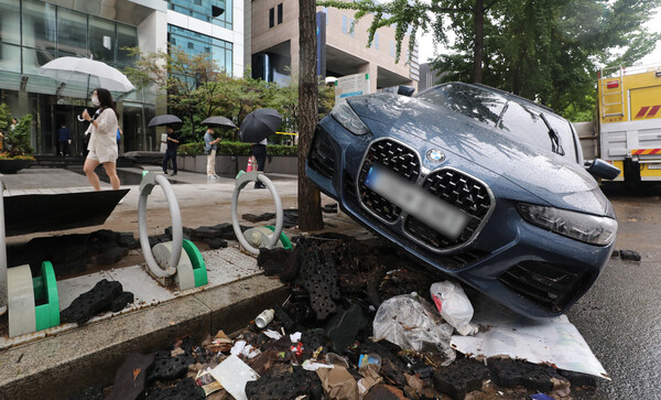서울 서초구 서초동 진흥아파트 앞 서초대로에 9일 오전 침수된 차량이 자전거 거치대에 올라와 있다.​​​​​​​(사진=뉴스1)
