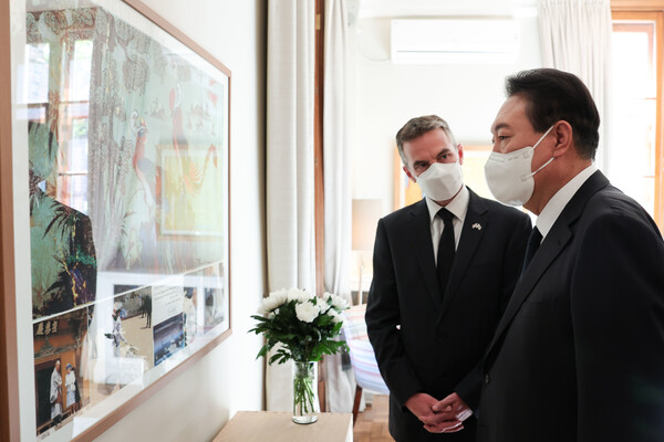 윤석열 대통령이 9일 오후 서울 중구 주한영국대사관을 찾아 엘리자베스 2세 여왕의 서거에 애도의 뜻을 표한 뒤 1999년 여왕의 방한 당시 사진을 보며 개러스 위어 대사대리의 설명을 듣고 있다. (사진=뉴스1)