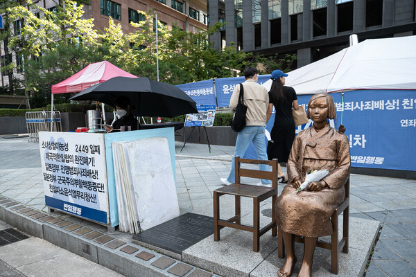'반일행동' 회원들이 12일 오전 서울 종로구 옛 일본대사관 앞 '평화의 소녀상을 지키고 있다.  