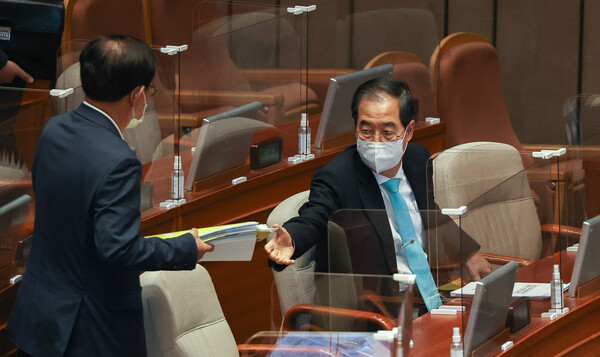 한덕수 국무총리가 20일 국회에 출석해 대정부질문에 답변하기 위해 준비 자료를 건네받고 있다.(사진=뉴스1)