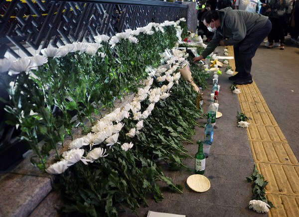  30일 저녁 서울 용산구 이태원 참사 사고 현장 인근에 국화꽃을 내려놓으며 희생자를 추모하고 있다.(사진=뉴스1)
