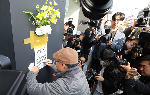 한 시민이 30일 오후 서울 용산구 이태원 압사 사고 현장 부근에서 꽃을 붙이고 추모글을 남기고 있다. (사진=뉴스1)