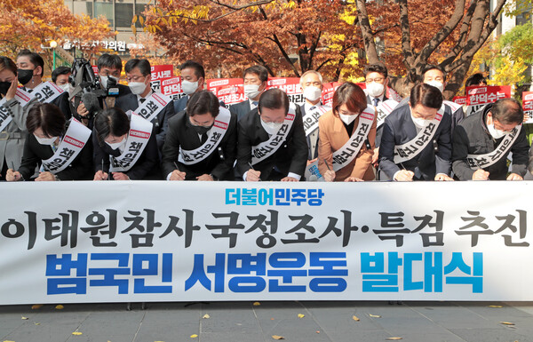 이재명 더불어민주당 대표를 비롯한 당 지도부들이 11일 서울 여의도역 인근에서 열린 이태원 참사 국정조사·특검 추진 범국민 서명운동 발대식에서 서명을 하고 있다.