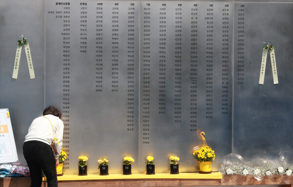 세월호 참사 7주기를 하루 앞둔 2021년 4월 15일 서울 광화문광장 세월호 기억 공간에서 현장 관계자가 희생자들의 명단 앞에 추모 화분을 올리고 있다. (사진=뉴스1)