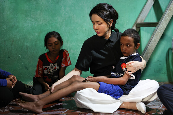 김건희 여사가 11월 12일 캄보디아 프놈펜에서 선천성 심장질환을 앓고 있는 14세 소년의 집을 찾아 소년을 앉고 있다. (사진=뉴스1 / 대통령실)