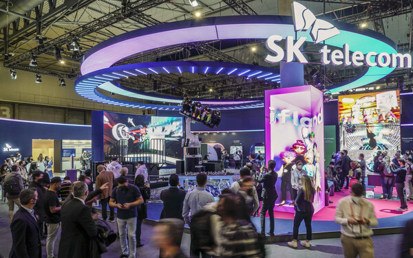 SKT가 지난해 'MWC2022'에서 메타버스를 앞세워 글로벌 관람객들의 관심을 끌고 있다. 사진은 4D메타버스 체험을 바라보는 관람객들과 SKT 전시관 전경. (사진=뉴스1 / SK텔레콤) 