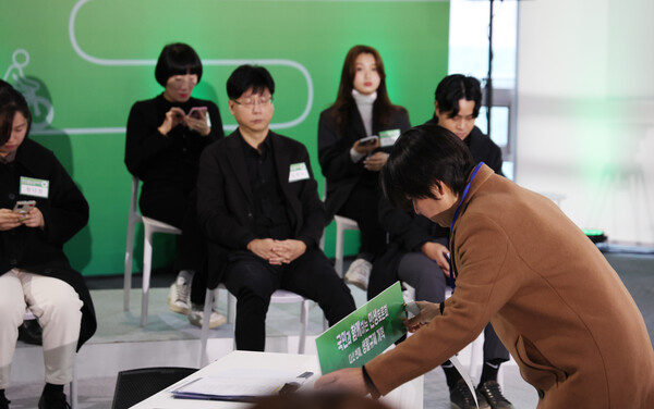 윤석열 대통령이 22일 서울 동대문구 한국콘텐츠진흥원 콘텐츠인재캠퍼스에서 예정된 '국민과 함께하는 민생토론회 - 다섯 번째, 생활규제 개혁'에 불참하기로 알려지자 관계자가 윤 대통령 자리를 정리하고 있다. (사진=연합뉴스)