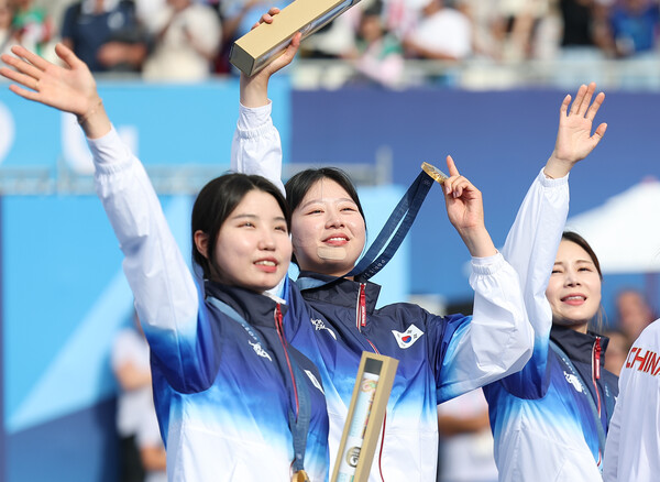  올림픽 10연패를 달성한 한국 여자 양궁대표팀 남수현, 임시현, 전훈영이 28일(현지시간) 프랑스 파리 레쟁발리드 양궁 경기장에서 열린 2024 파리올림픽 양궁 여자단체전 시상식에서 금메달을 들고 관중을 향해 손을 흔들고 있다. (사진=연합뉴스)