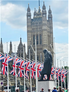 웨스트민스터 의사당을 배경으로 한 유니언 잭의 행렬. 의회 개원식 날(2024. 7. 17)이라 거리에 많은 국기 게양. 앞의 동상은 윈스턴 처칠.