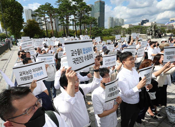 의대교수들이 3일 오후 서울 용산구 대통령실 인근에서 열린 결의대회에서 손팻말을 들고 있다. (사진=연합뉴스)