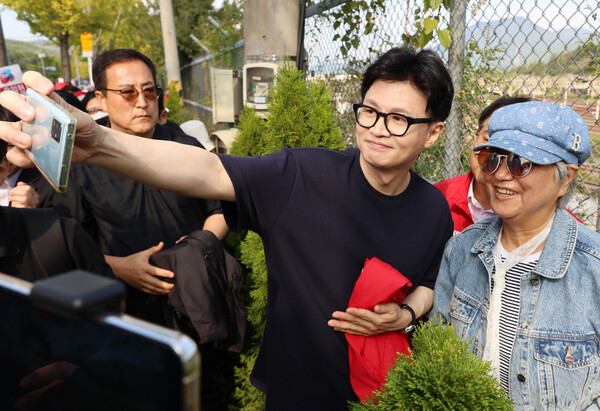 한동훈 국민의힘 대표가 12일 오후 부산 금정구 거리 일대를 걸으며 윤일현 금정구청장 보궐선거 후보와 유세를 펼치고 있다. 가운데 빨간 옷이 윤일현 후보. (사진=연합뉴스)