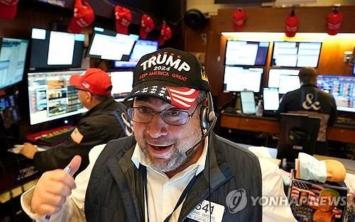 트럼프 모자를 쓴 뉴욕증권거래소 트레이더가 모니터를 바라보고 있다. 6일(현지시간) 뉴욕증시 3대 지수는 모두 사상 최고가를 경신했다. (사진=연합뉴스)