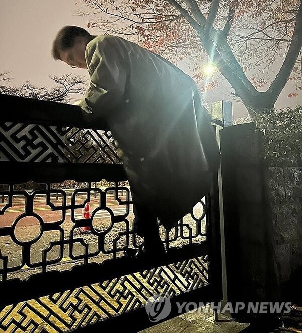 대통령 비상계엄으로 경찰이 통제 중인 서울 여의도 국회에서 3일 밤 11시쯤 우원식 국회의장이 국회 본청으로 들어가기 위해 국회 담을 넘고 있다. (사진)