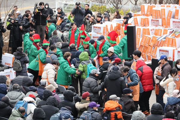 크리스마스인 25일 서울 동대문구 다일공동체 밥퍼나눔운동본부 앞마당에서 열린 '소외된 이웃과 함께하는 37번째 거리 성탄예배'에서 참석자들이 방한복과 도시락을 받고 있다. (사진=연합뉴스)