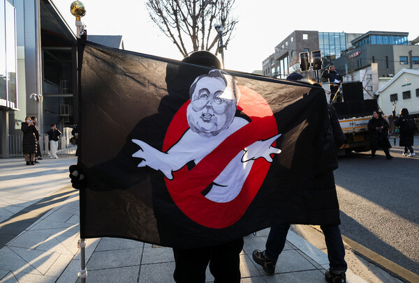 서울 한남동 윤석열 거주지 앞에서 한 시민이 윤석열 체포를 촉구하는 깃발을 들고 있다. 로이터는 3일 윤석열에 대한 체포영장이 집행되지 못했다고 공수처 관계자 발언을 인용해 보도했다. (사진=연합뉴스 / 로이터)