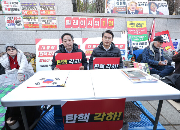국민의힘 윤상현, 강승규 의원이 11일 서울 종로구 헌법재판소 앞에서 윤석열 탄핵심판 각하 촉구 릴레이 시위를 하고 있다. (사진=연합뉴스)