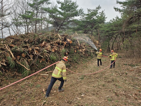 27일 경북 안동시 풍천면 병산서원 인근에서 소방관들이 벌목 후 물을 뿌리며 산불 방어선을 구축하고 있다. (사진=연합뉴스 / 경북소방본부)