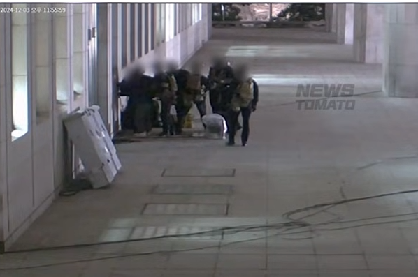 12.3 비상계엄 당시  계엄군이 유지웅 뉴스토마토 기자를 국회 본관 벽으로 밀어붙여 제압한 뒤 케이블타이로포박을 시도하는 모습. 국회 본관 CCTV에 담긴 장면인데,  화면 왼쪽 상단에는 12월 3일 오후 11시 35분 59초라고 찍혀 있다. (제공=뉴스토마토)