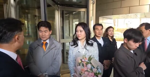 11일 서울 한남동 관저에서 서초동 자택으로 복귀하는 윤석열 부부를 마중하기 위해 전한길(왼쪽에서 두 번째)씨와 계몽 김계리 변호사가 서초동 아크로비스타 건물 입구에 나란히 서 있다. (사진=X캡처)