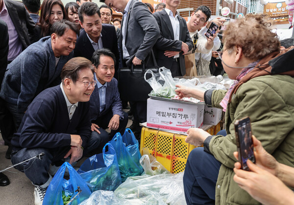 이재명 더불어민주당 대선 후보가 '골목골목 경청투어: 단양8경편'에 나선 4일 강원 영월군 영월서부시장에서 엄나무 순을 팔고 있는 상인과 대화하고 있다. (사진=연합뉴스)