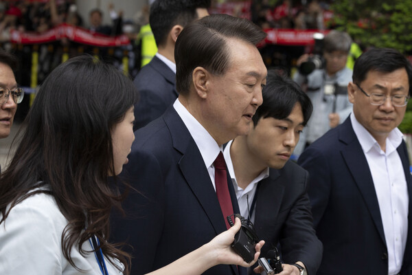 윤석열 전 대통령이 19일 서울 서초구 서울중앙지방법원에서 열린 내란 우두머리 혐의, 직권남용 권리행사방해 혐의 사건 4차 오전 공판을 마친 후 취재진의 질문을 받으며 이동하고 있다. (사진=연합뉴스) 