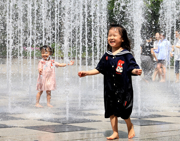 덥고 습한 공기 유입으로 찜통더위가 찾아온 21일 서울 성동구 서울숲에서 어린이들이 분수 물줄기에 즐거워하고 있다. (사진=연합뉴스)