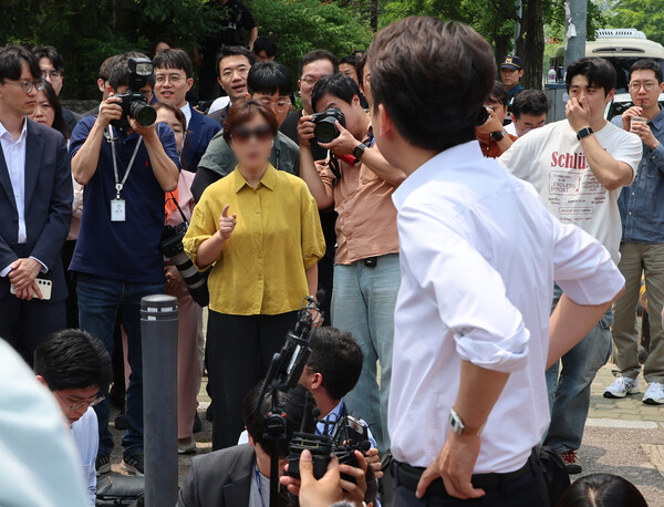 이준석 개혁신당 대선 후보가 28일 서울 여의도공원에서 유세를 마치고 백브리핑을 하던 중 한 시민으로부터 전날 TV토론회에서 여성 신체에 대한 폭력적 표현을 언급한 것과 관련해 항의받고 있다. (사진=연합뉴스)