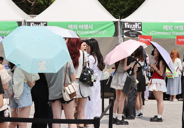 낮 최고 기온 33도를 기록한 19일 서울 송파구 올림픽공원 케이스포돔에서 열리는 '2025 마이케이 페스타(MyK FESTA) 케이팝 콘서트'를 찾은 외국인들이 입장권을 받기 위해 줄을 서 있다. (사진=연합뉴스)