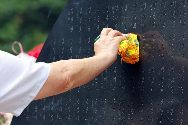 29일 서울 서초구 매헌시민의숲 삼풍참사위령탑을 찾은 유족이 희생자를 추모하며 희생자 이름이 새겨진 위령탑을 손수건으로 닦고 있다.(사진=연합뉴스)
