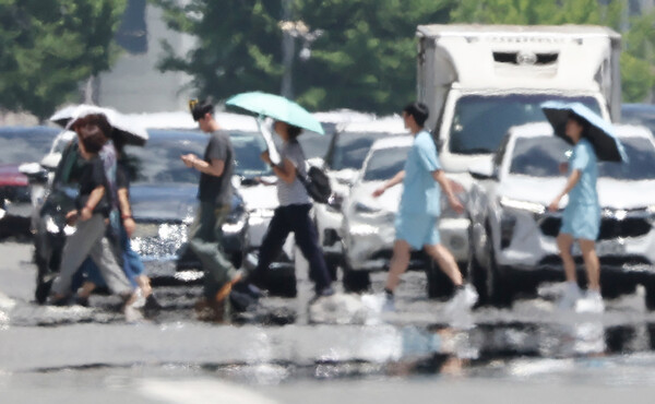 11일 폭염 속에서 시민들이 길을 건너고 있다.
