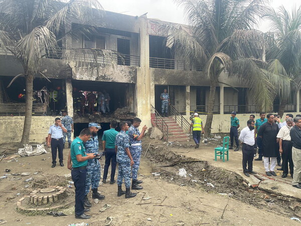 22일(현지시간) 방글라데시 수도 다카 북쪽 우타라 지역 학교에 공군 훈련기가 추락해 사망자 30명을 넘어선 것으로 파악된 가운데 공군 조사관들이 현장 조사를 실시하고 있다. (사진=다카 EPA/연합뉴스)