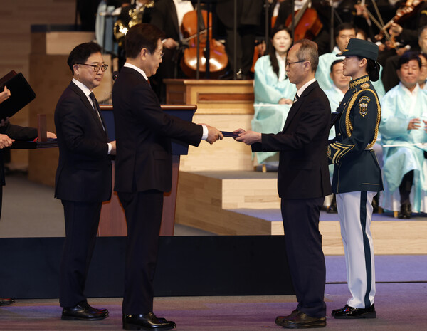 이재명 대통령이 15일 서울 세종문화회관에서 열린 80주년 광복절 경축식에서 고(故) 이은숙 선생의 외손자 김종민 씨에게 건국훈장 애족장 훈장증을 전달하고 있다. (사진=연합뉴스)