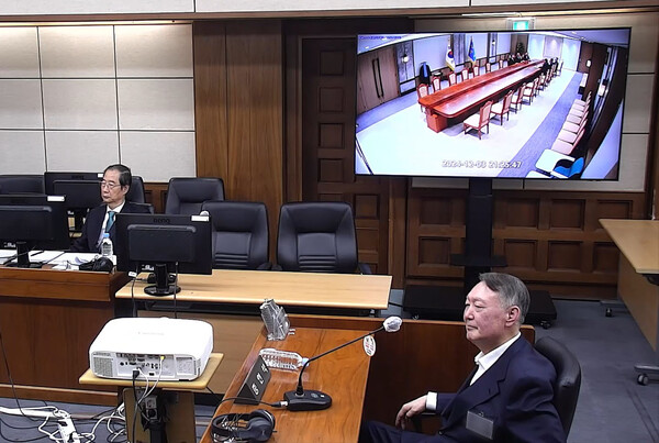 내란  우두머리 피고인 윤석열이 19일 서울중앙지방법원에서 열린 한덕수 전 국무총리의 내란 재판에 증인으로 출석해 증거 CCTV 영상을 지켜보고 있다. (사진=연합뉴스)