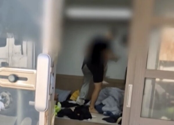 강원 양양군 7급 공무원이 쉼터에서 '계엄령 놀이'라며 이불 속 환경민화원을 발로 밟는 모습. MBC 보도 화면 캡쳐.